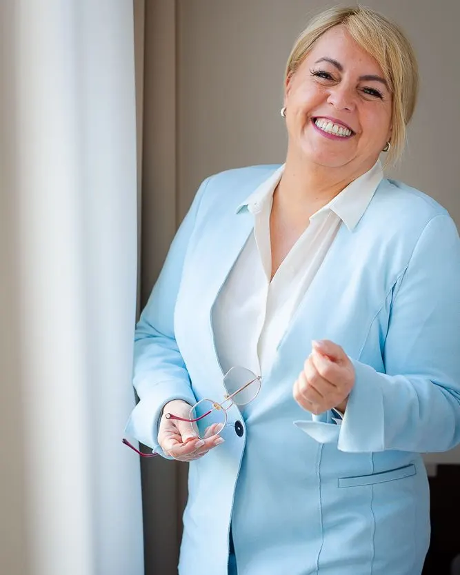 Claudia Conen lacht im hellblauen Anzug
