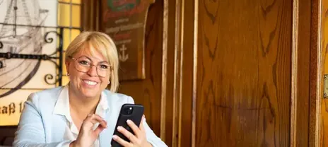 Claudia Conen im Gespräch am Telefon, warmes Licht